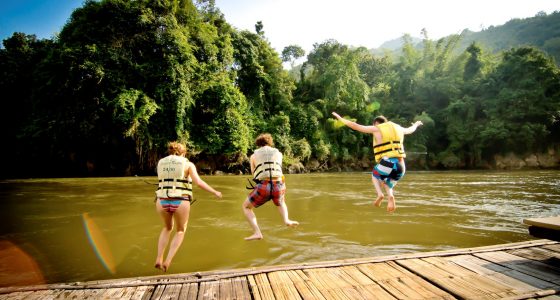 tre mennesker hopper ut i elven ved hotellet jungle rafts river kwai i hua hin
